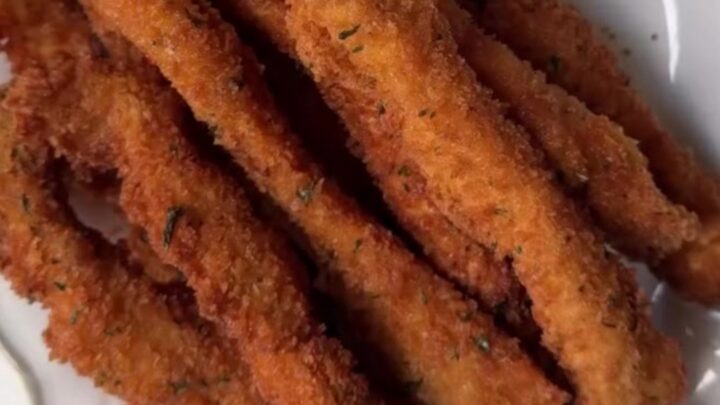 Golden crispy chicken fries piled in a paper cone with honey mustard for dipping