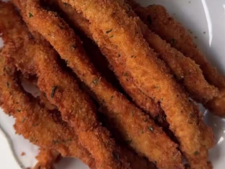 Golden crispy chicken fries piled in a paper cone with honey mustard for dipping