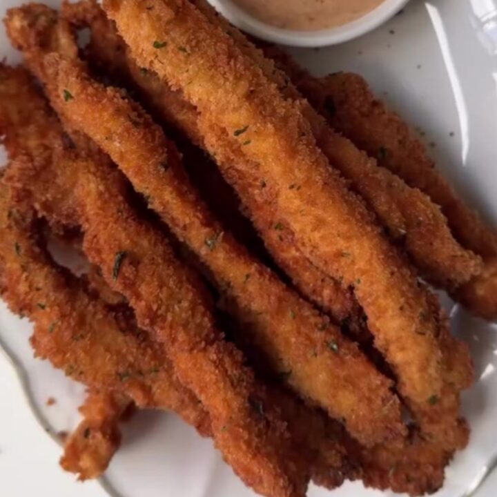 Golden crispy chicken fries piled in a paper cone with honey mustard for dipping