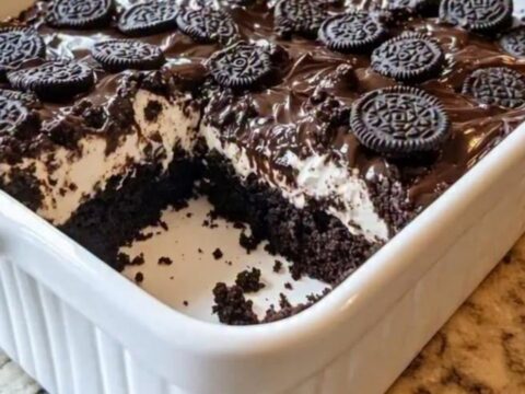 A warm slice of Oreo Earthquake Cake lifted with a spatula, revealing molten chocolate and cream cheese.