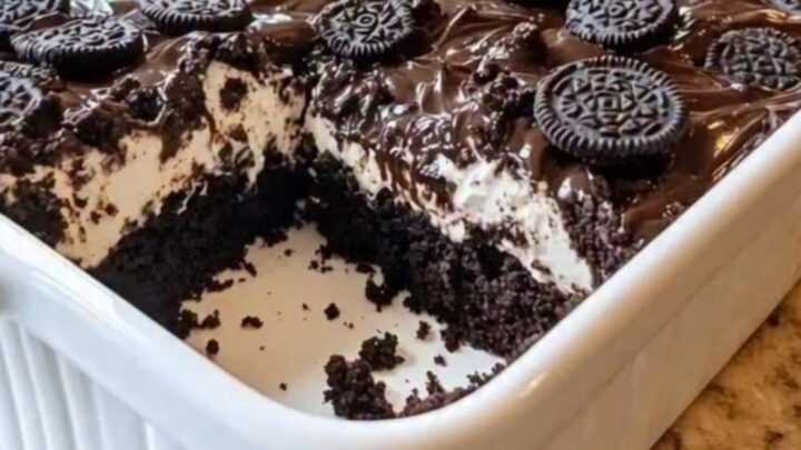 A warm slice of Oreo Earthquake Cake lifted with a spatula, revealing molten chocolate and cream cheese.