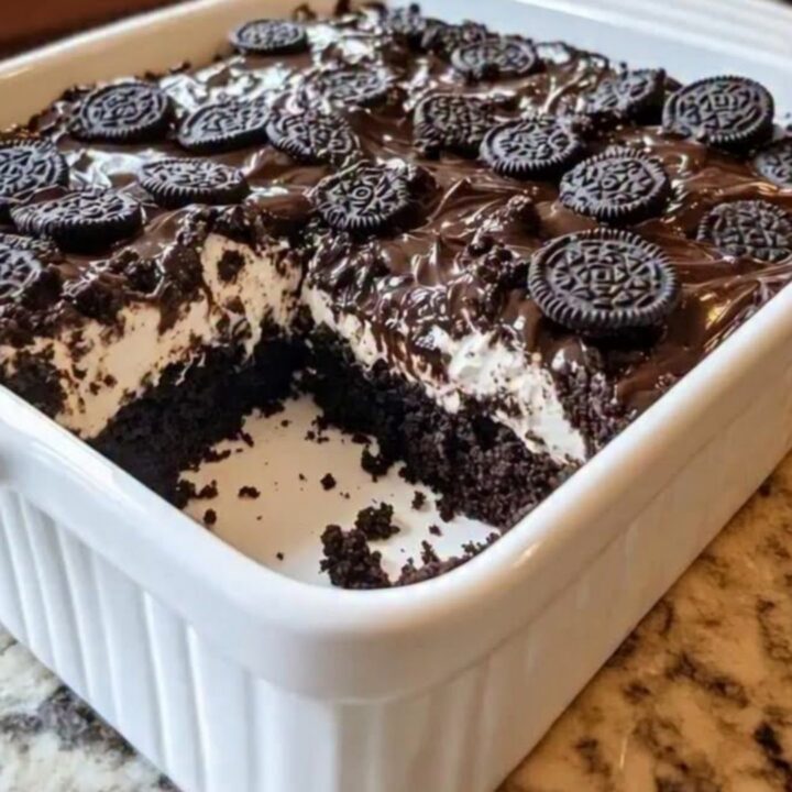 A warm slice of Oreo Earthquake Cake lifted with a spatula, revealing molten chocolate and cream cheese.