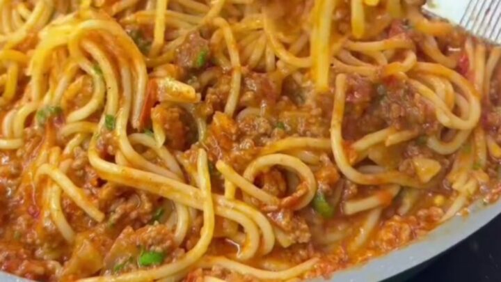 Baked rigatoni with meatballs and a blistered mozzarella crust, garnished with fresh basil
