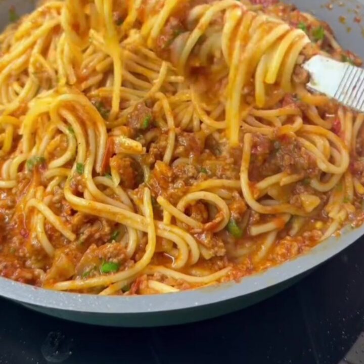 Baked rigatoni with meatballs and a blistered mozzarella crust, garnished with fresh basil