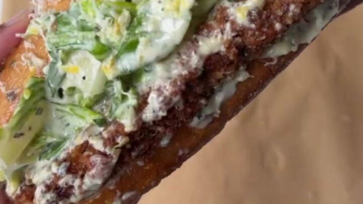 Crispy chicken Caesar sandwich with brioche bun, romaine slaw, and shaved parmesan
