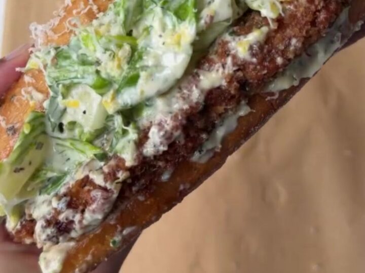 Crispy chicken Caesar sandwich with brioche bun, romaine slaw, and shaved parmesan