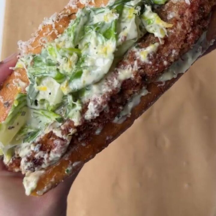 Crispy chicken Caesar sandwich with brioche bun, romaine slaw, and shaved parmesan