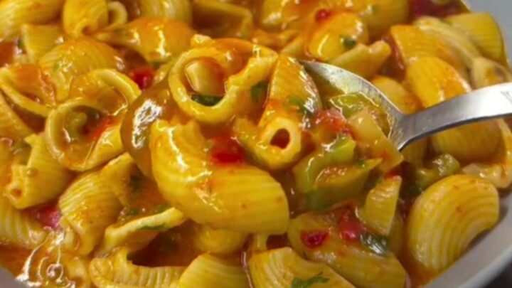 Baked feta shell pasta in a baking dish, creamy pink sauce coating shells, garnished with basil and parmesan.