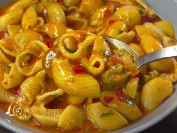 Baked feta shell pasta in a baking dish, creamy pink sauce coating shells, garnished with basil and parmesan.