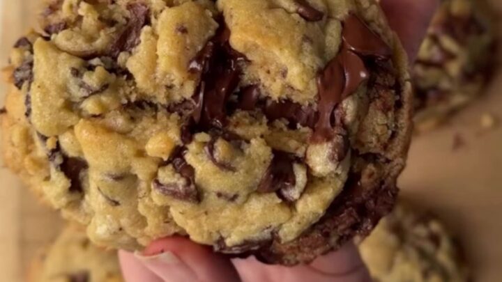 Gooey chocolate chip cookie broken in half with melted chocolate pulling