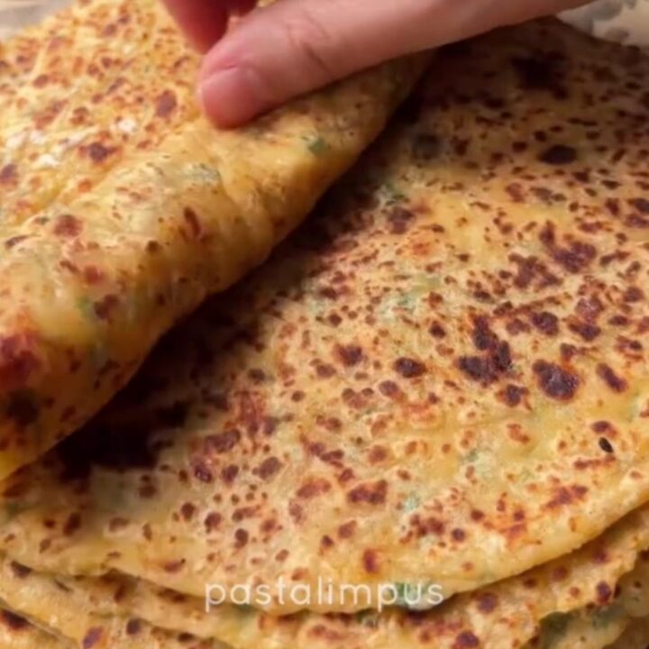 Golden blistered Turkish gözleme sliced into triangles, showing creamy potato and melted cheese filling.