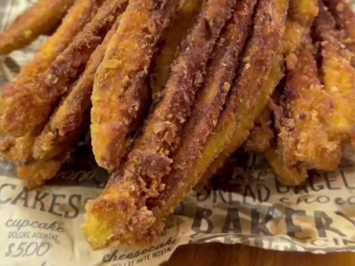 Crispy accordion eggplant fries on a wire rack, golden brown and steaming, with a bowl of garlic yogurt dip.