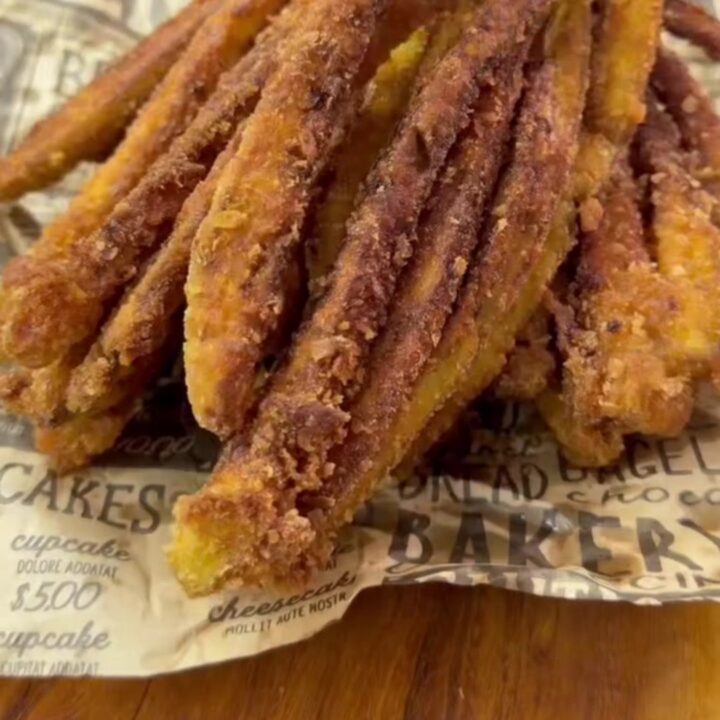 Crispy accordion eggplant fries on a wire rack, golden brown and steaming, with a bowl of garlic yogurt dip.