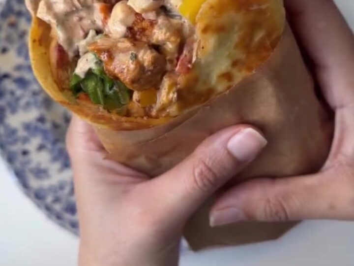 Crispy chipotle chicken wrap sliced diagonally, showing melted cheese and juicy chicken.