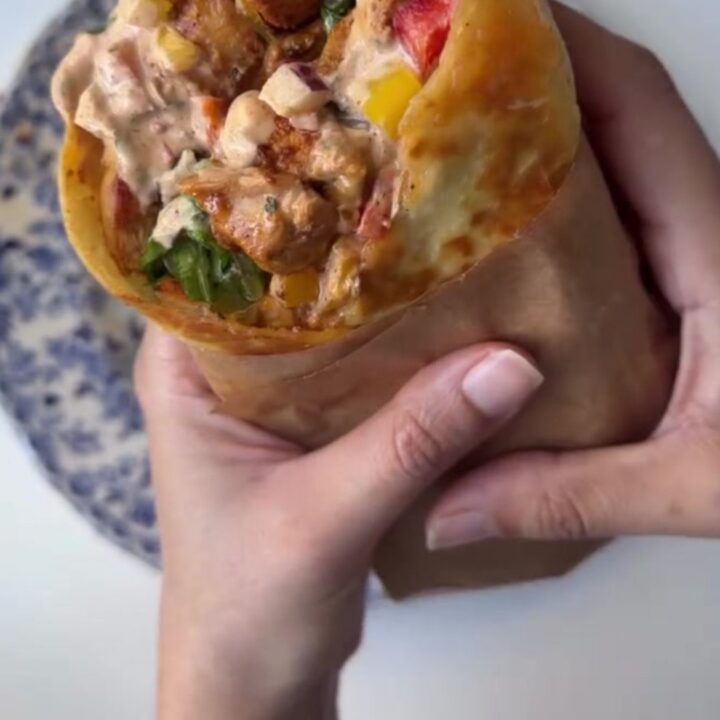 Crispy chipotle chicken wrap sliced diagonally, showing melted cheese and juicy chicken.
