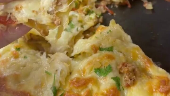 Golden tortilla pie with bubbling cheese and garlic butter, cut into a wedge with cheese stretching.