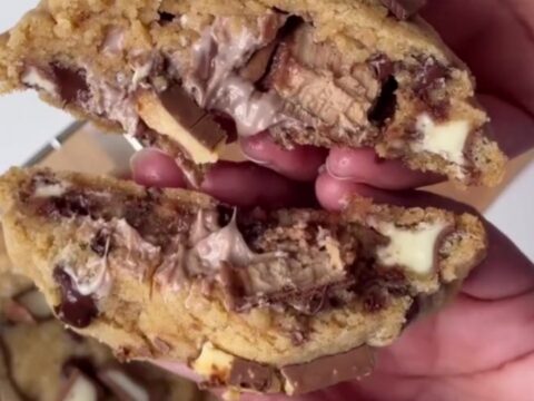 Giant cookie being broken open showing molten hazelnut cream and chocolate flowing out