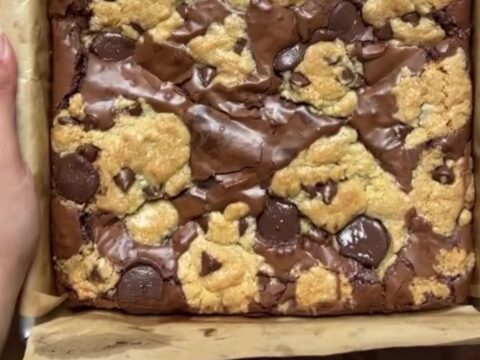 Stack of brookies with visible brownie and cookie layers, topped with flaky sea salt