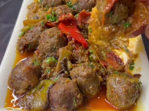 Turkish meatball and vegetable casserole in a baking dish with rich tomato sauce and parsley