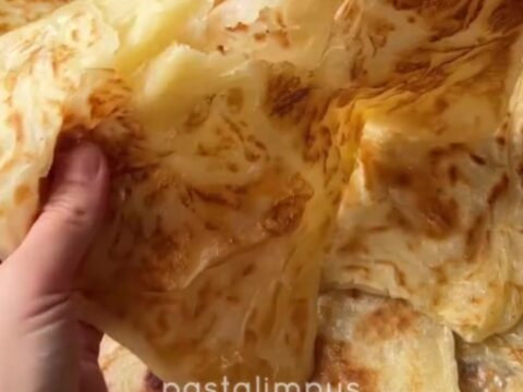 Golden Tokat Katmeri flatbread with visible flaky layers, pulled apart to show steam