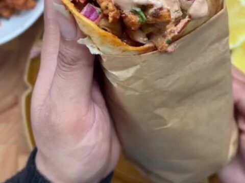 Crispy chipotle chicken wrap sliced in half, showing juicy chicken, melted mozzarella, and creamy sauce