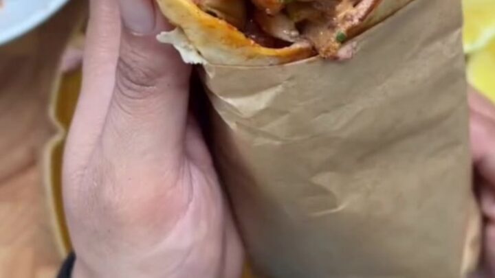 Crispy chipotle chicken wrap sliced in half, showing juicy chicken, melted mozzarella, and creamy sauce