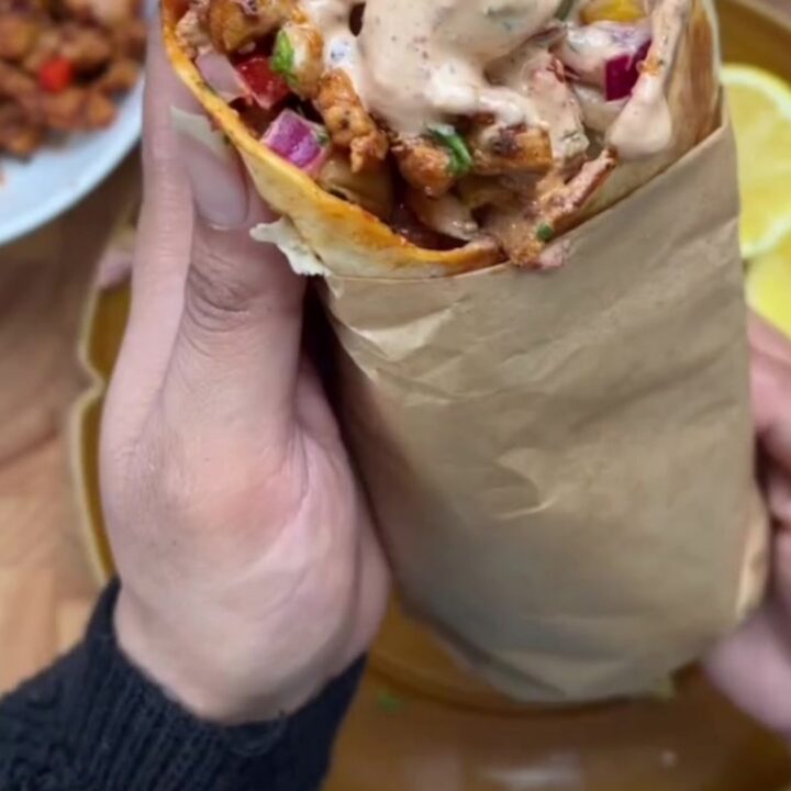Crispy chipotle chicken wrap sliced in half, showing juicy chicken, melted mozzarella, and creamy sauce