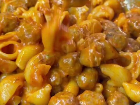 Spoon scooping rigatoni with roasted tomato sauce and melted mozzarella cheese pull