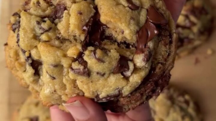 Two-chip bakery cookies with crispy edges and gooey centers on a cooling rack