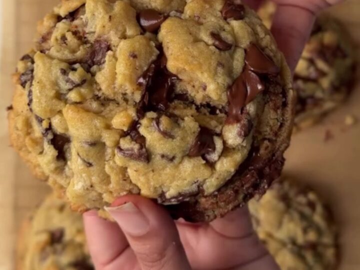 Two-chip bakery cookies with crispy edges and gooey centers on a cooling rack