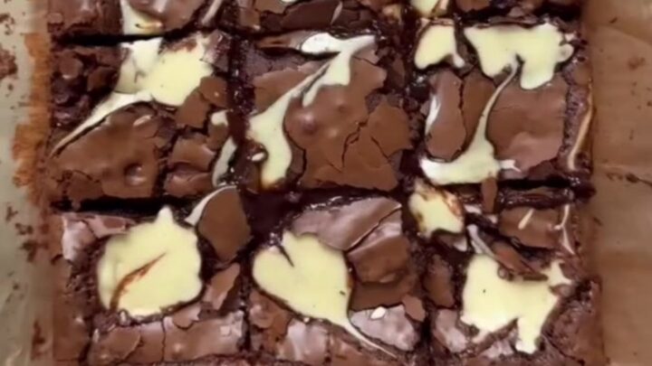 Brown butter cheesecake brownies cut into squares, showing fudgy chocolate and creamy swirls