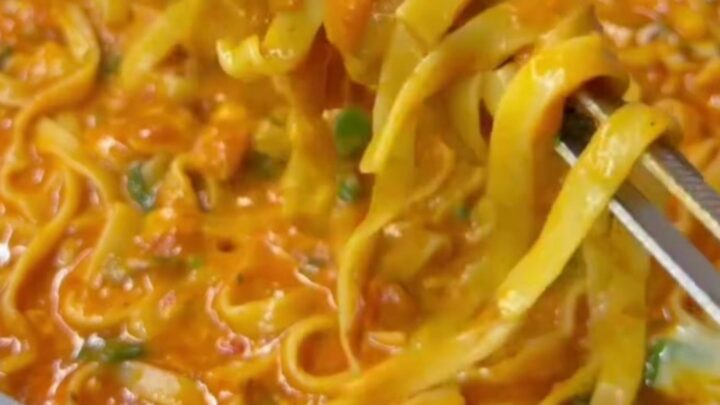 Tagliatelle with roasted tomato sauce and melted mozzarella, topped with fresh basil