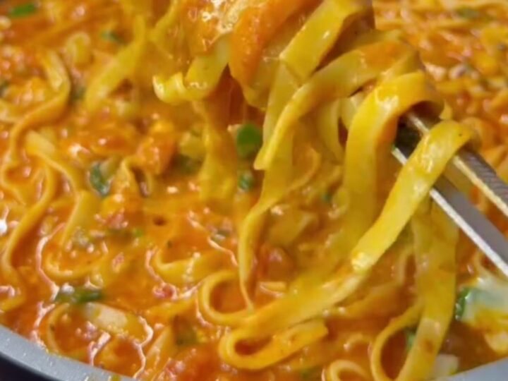 Tagliatelle with roasted tomato sauce and melted mozzarella, topped with fresh basil