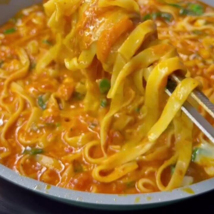 Tagliatelle with roasted tomato sauce and melted mozzarella, topped with fresh basil