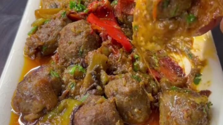Turkish meatball and roasted eggplant casserole in a baking dish with parsley and crusty bread