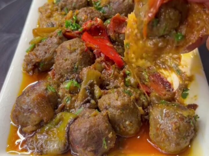 Turkish meatball and roasted eggplant casserole in a baking dish with parsley and crusty bread