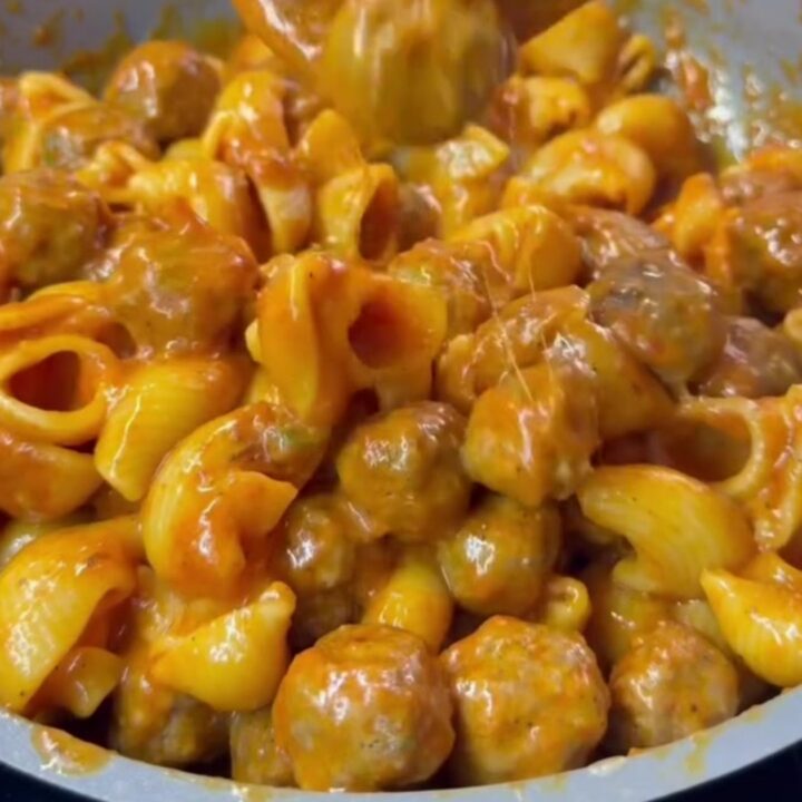 One-pan stuffed shell pasta and meatball bake with melted mozzarella and basil, served in a skillet