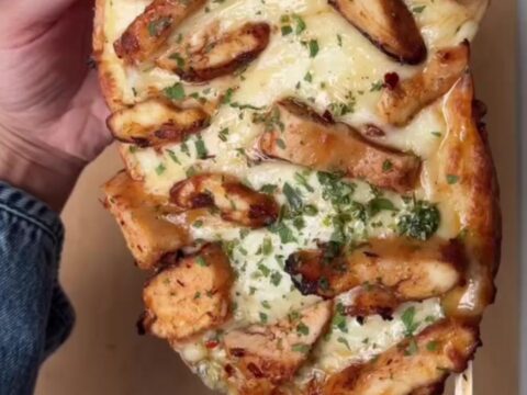 Sliced stuffed baguette with melted mozzarella stretching between pieces