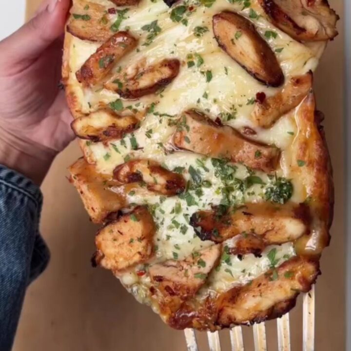 Sliced stuffed baguette with melted mozzarella stretching between pieces