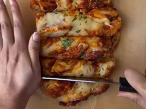 Whole garlic baguette stuffed with butter chicken and mozzarella, golden and bubbling