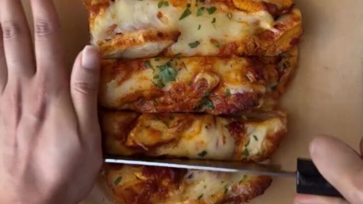 Whole garlic baguette stuffed with butter chicken and mozzarella, golden and bubbling