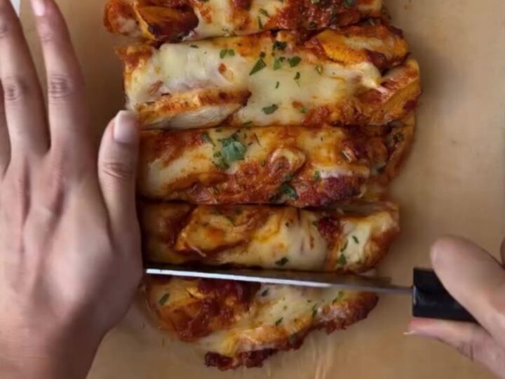 Whole garlic baguette stuffed with butter chicken and mozzarella, golden and bubbling