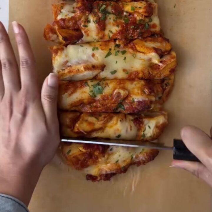 Whole garlic baguette stuffed with butter chicken and mozzarella, golden and bubbling