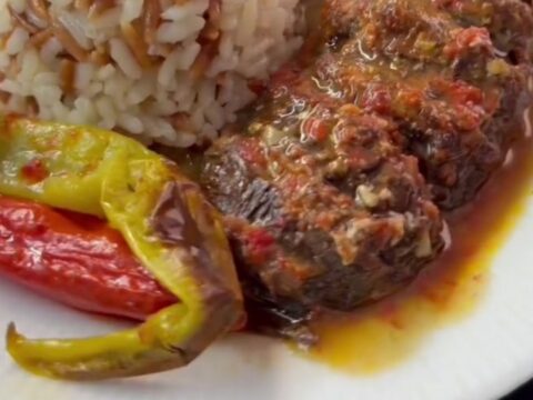 Turkish meatball and roasted eggplant casserole in a baking dish with tomato sauce and parsley