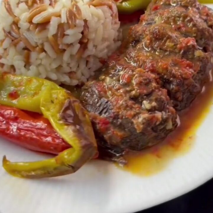 Turkish meatball and roasted eggplant casserole in a baking dish with tomato sauce and parsley