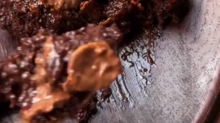 A dark, glossy Turkish wet chocolate cake with fudge sauce oozing from the crumb, topped with crispy chocolate pearls.