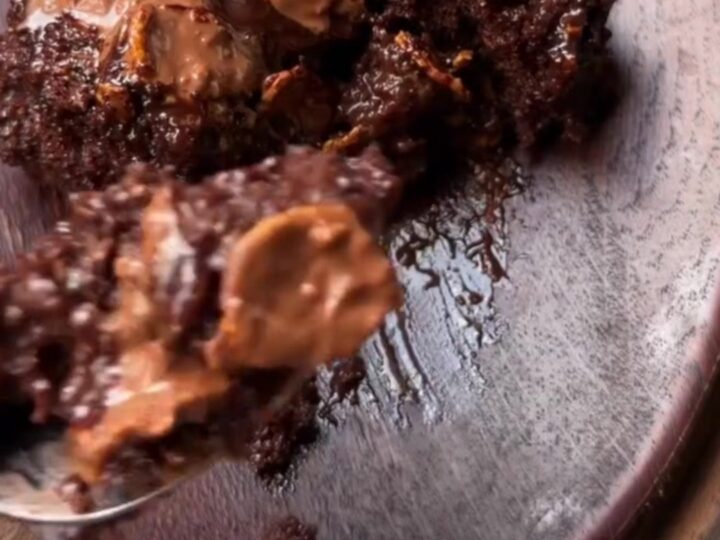 A dark, glossy Turkish wet chocolate cake with fudge sauce oozing from the crumb, topped with crispy chocolate pearls.