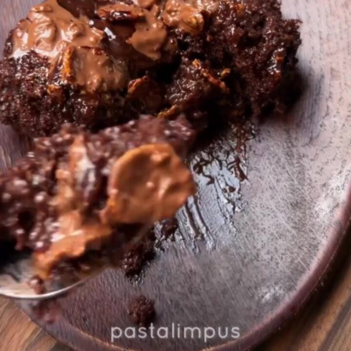 A dark, glossy Turkish wet chocolate cake with fudge sauce oozing from the crumb, topped with crispy chocolate pearls.