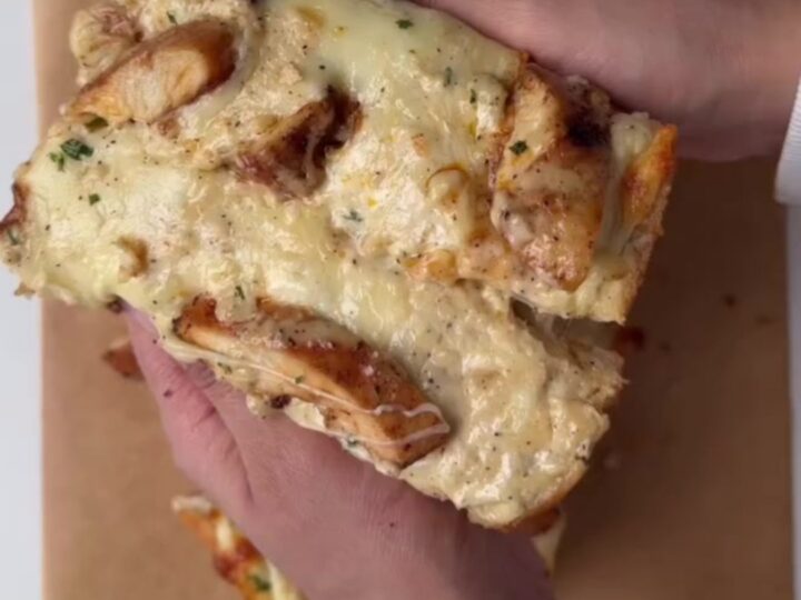 Golden garlic bread with blistered mozzarella and cheddar, pulled apart showing cheese stretch