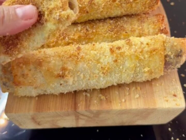 Crispy golden Paçanga böreği rolls on a plate, one torn open with melted cheese stretching